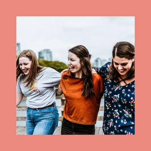 Amigas sorrindo, celebração e amizade ao ar livre, destaque para união e felicidade.
