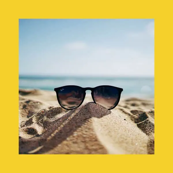 óculos de sol praia areia verão ambiente relaxante.