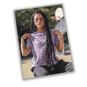 Capa de foto de mulher com cabelos longos e trançados, óculos roxos, na rua, estilo urbano e moda jovem.