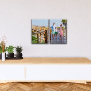 Família caminhando na passarela de madeira com vista para o mar, decorações modernas e natureza ao redor.